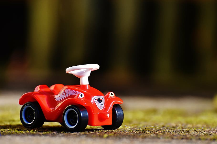 selective-focus photography of red plastic car toy, bobby car