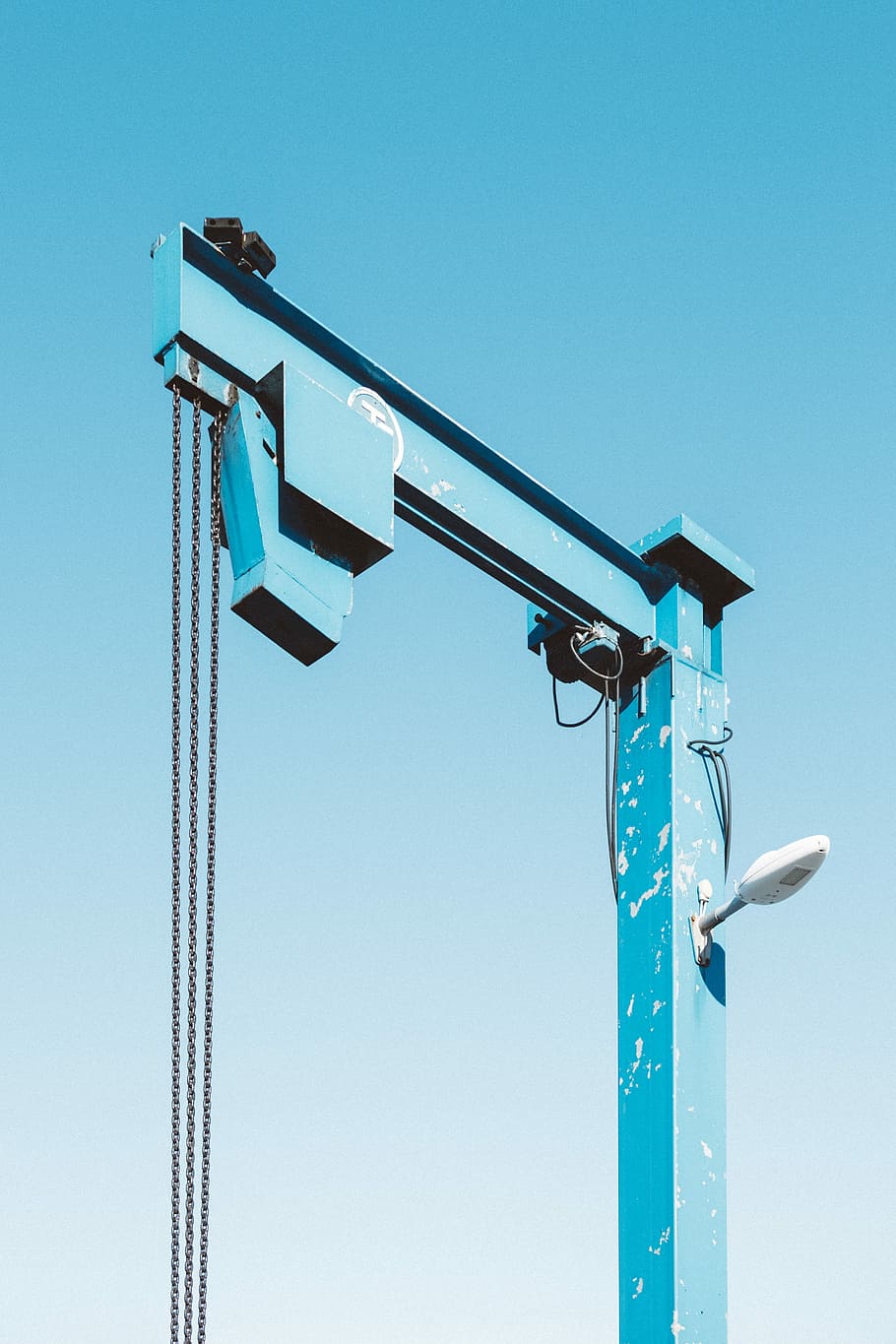 blue lift machine under blue skies, blue metal construction post