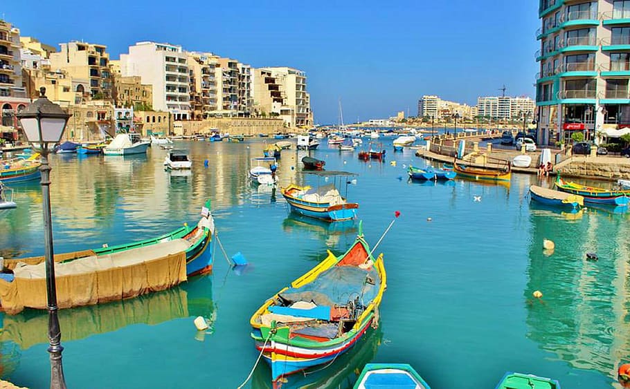 assorted-color boats floating on body of water beside buildings at daytime HD wallpaper