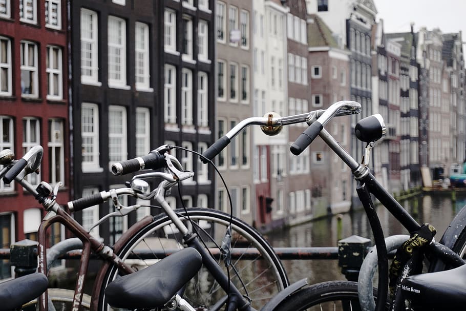brown and black city bikes padlocked on black steel rail, two city bicycle on bridge railings, HD wallpaper