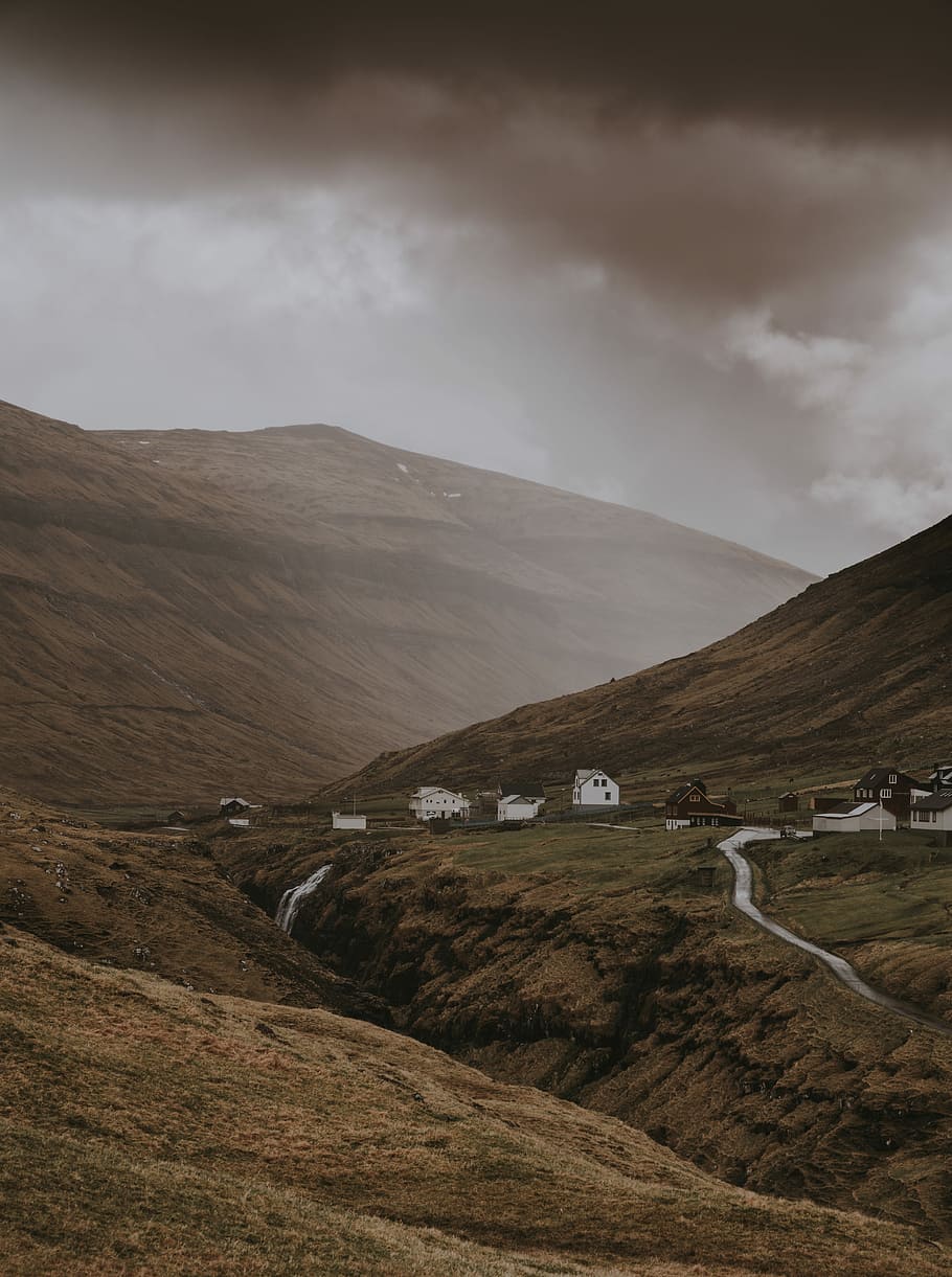landscape photo of mountain, houses near mountain under cloudy sky at daytime HD wallpaper