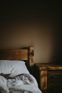Bedtime, brown wooden bed with white bedspread inside dim light room HD wallpaper