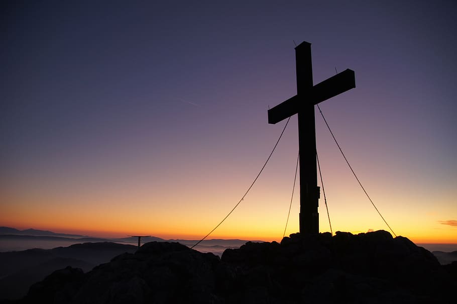 silhouette of cross on mountain peak during golden hour, summit cross