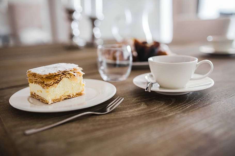 Sweet dessert with cream and a cup of coffee on a table, cake