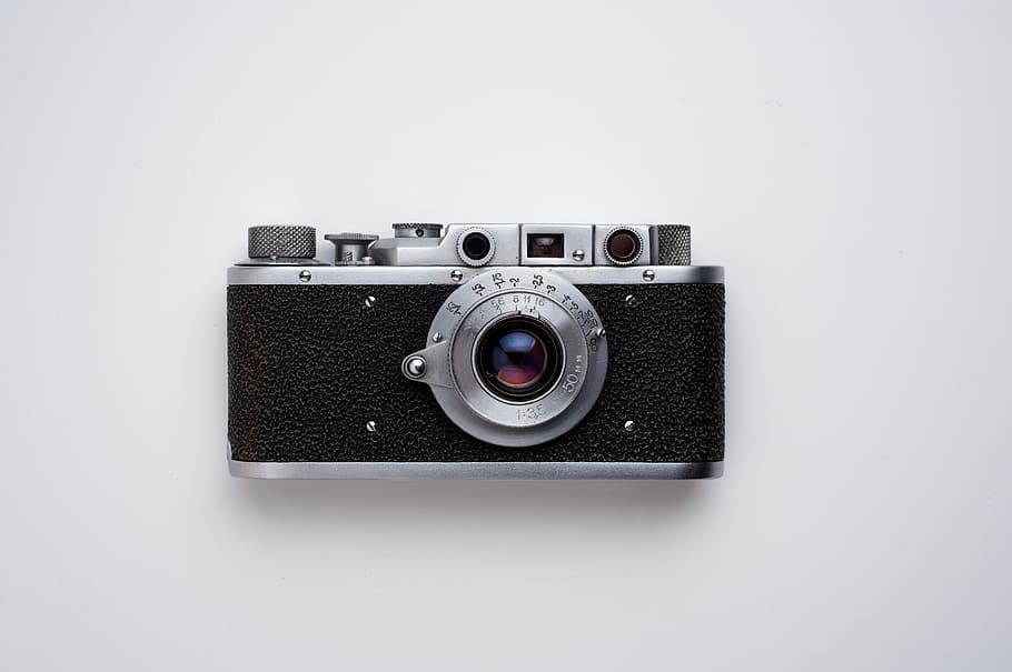 black and gray SLR camera on white background, shallow focus photography of camera