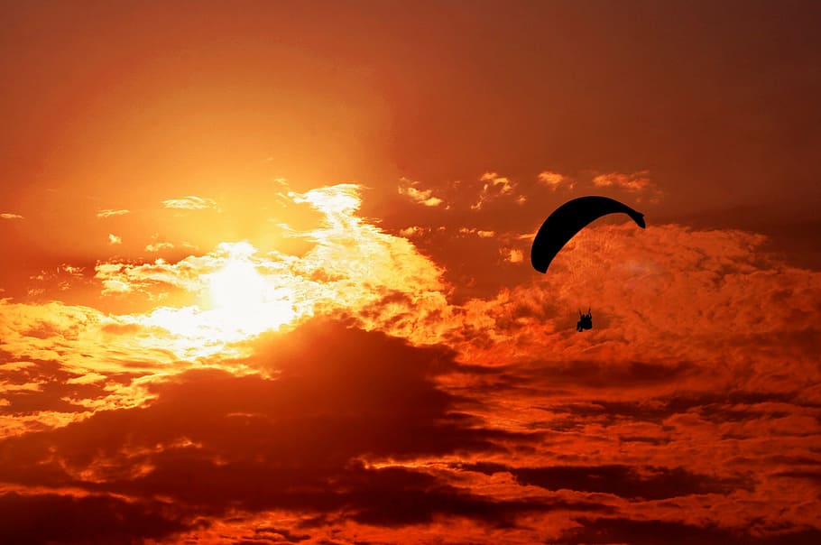 person riding parachute near clouds, sunset, orange, paragliding HD wallpaper