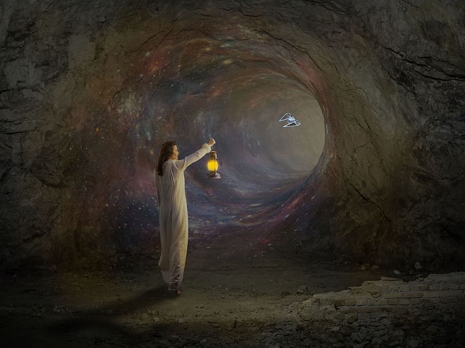 person holding lamp inside cave, worm hole, voltage, hope, illusion