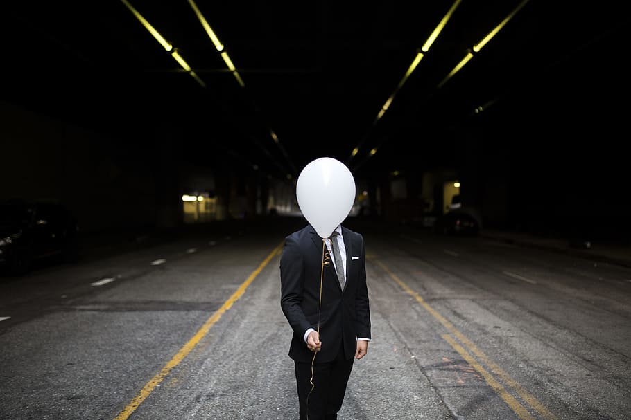man in formal suit standing while holding white balloon, men in black suit jacket on road HD wallpaper