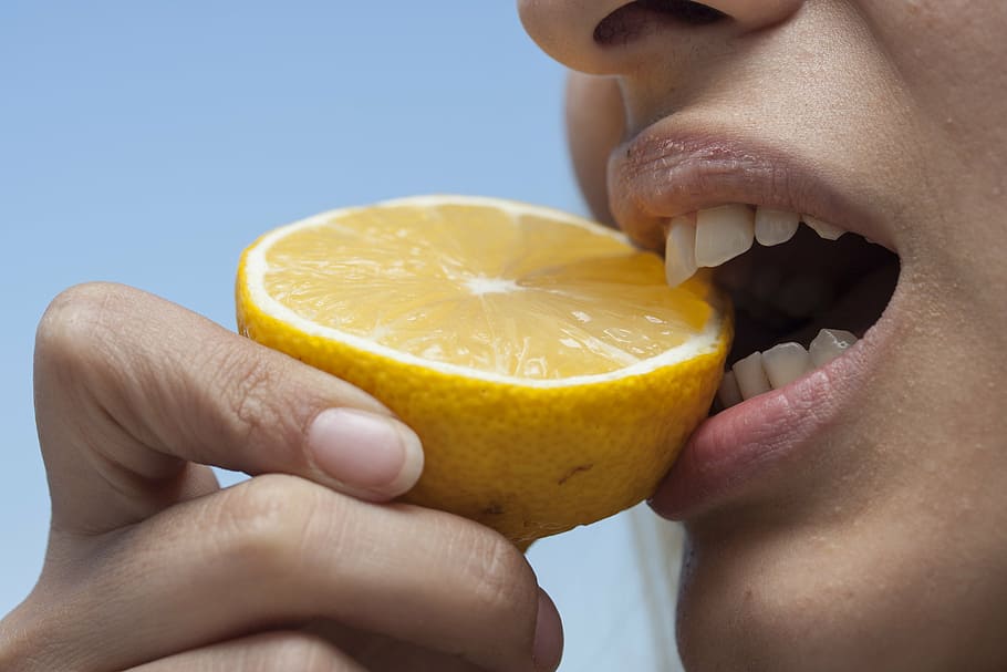 close photo of person biting yellow citrus fruit, eating, bite HD wallpaper