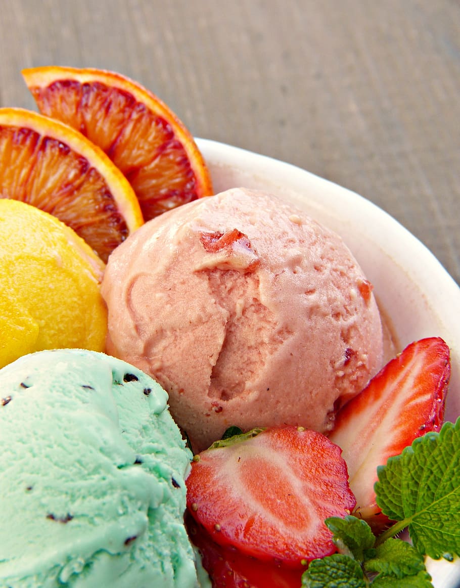 ice cream surrounded with slice strawberry and orange, ice cream sundae
