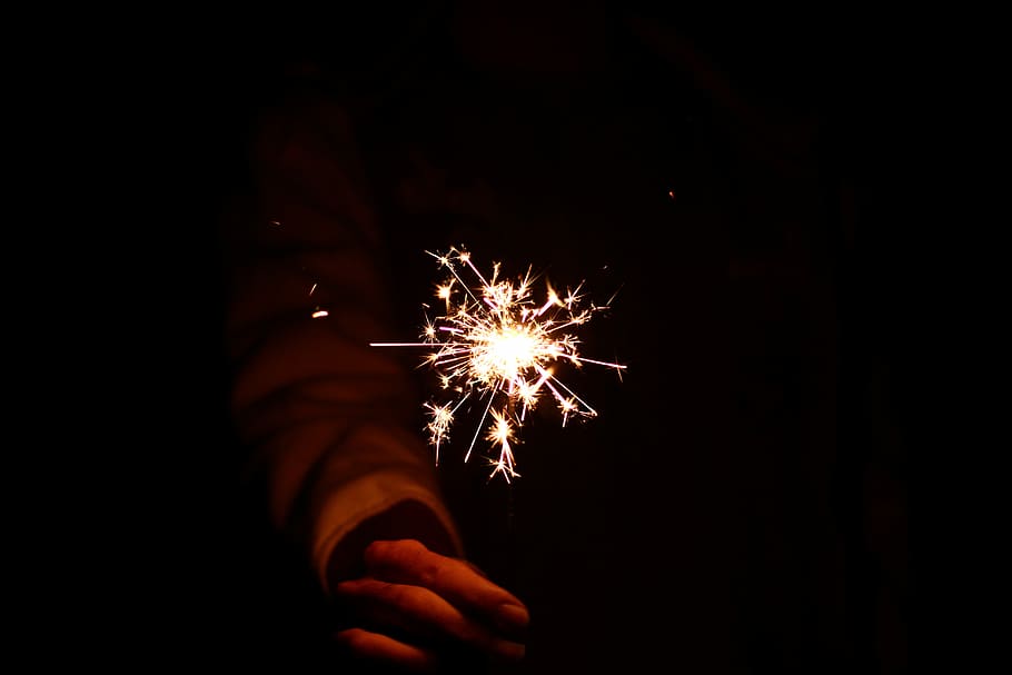firework spark, person holding firecracker, night, dark, hand