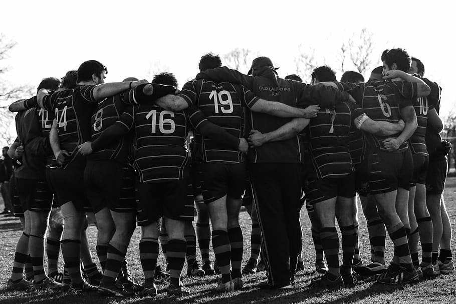 grayscale photography of group of men in huddle, team, togetherness