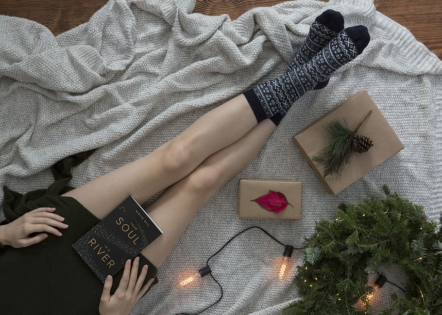woman wearing gray and black socks, person sitting beside string lights and wreath holding book HD wallpaper