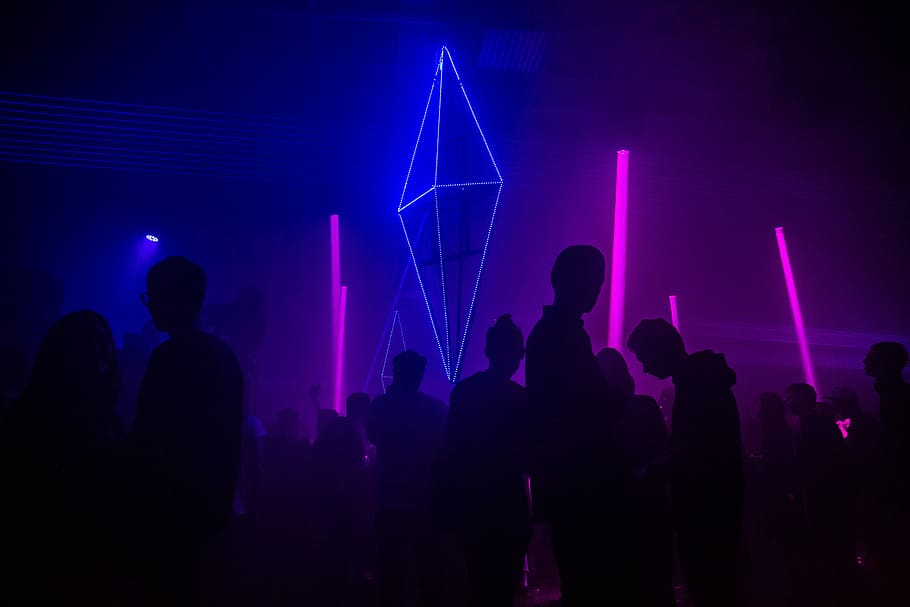 silhouette photography of people gathered inside bar, silhouette of people standing on dance floor surrounded with lights