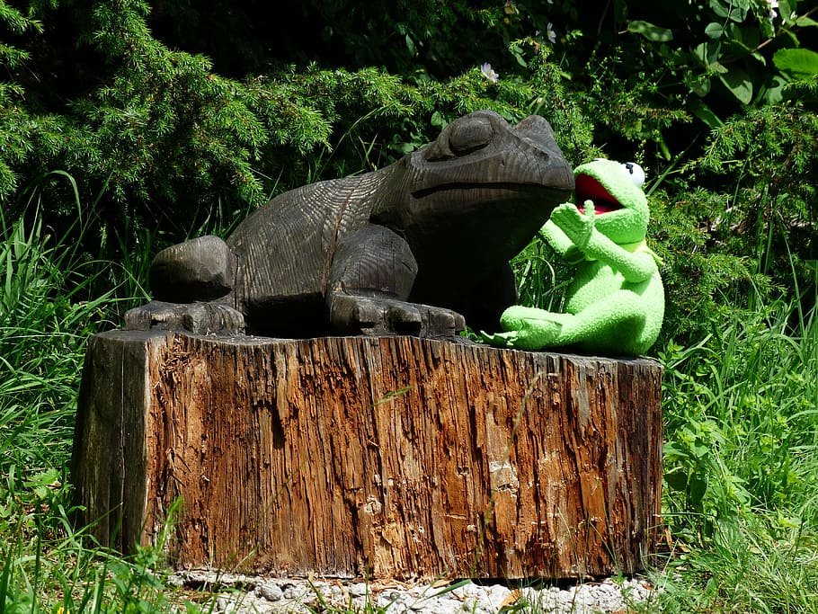 green Kermit the Frog sitting beside gray frog statue, talk, talk about a