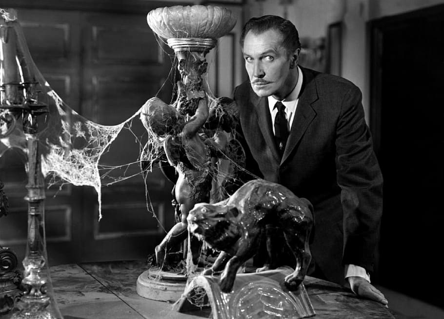 man standing in front of statuette, vincent price, actor, vintage
