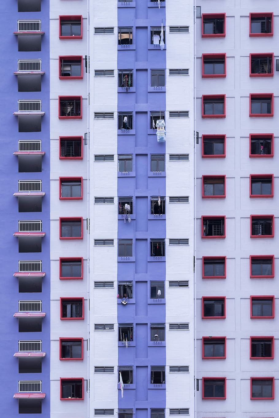 blue and white high-rise building, building with clothes outside during daytime HD wallpaper