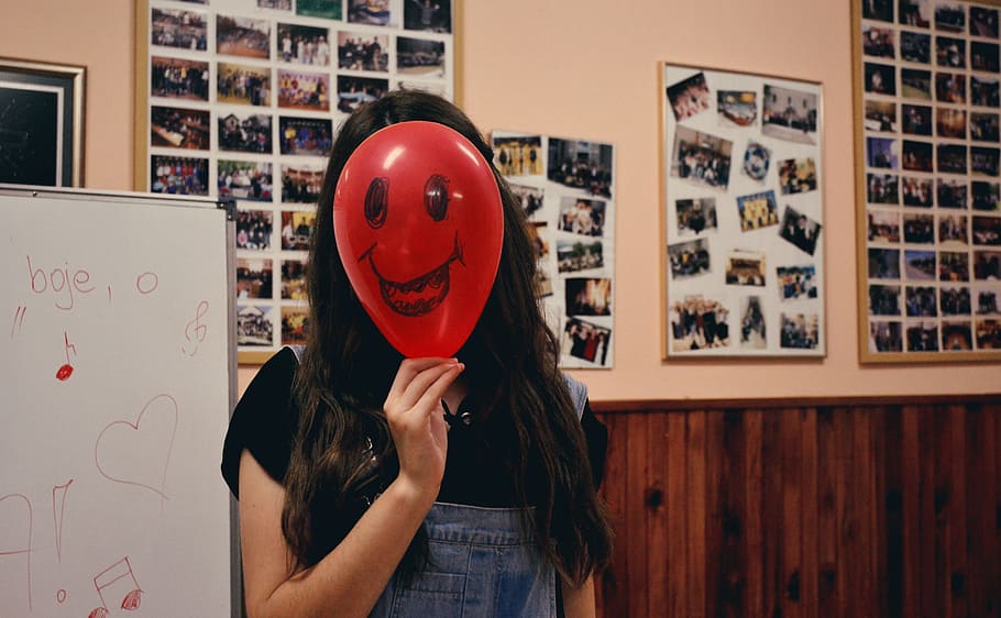 Woman Holding Red Balloon on Her Face Photo Inside Classroom HD wallpaper