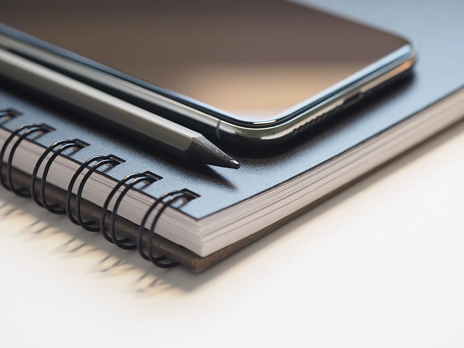 space gray iPhone X on top of spiral notebook, close- up, macro HD wallpaper