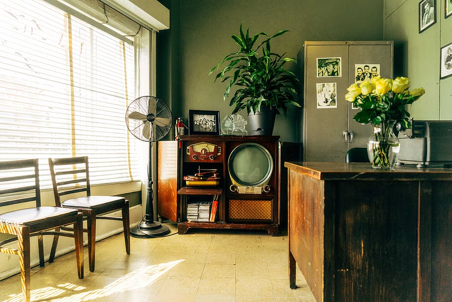 grey pedestal fan near brown wooden rack inside house, classic television beside pedestal fan inside an office