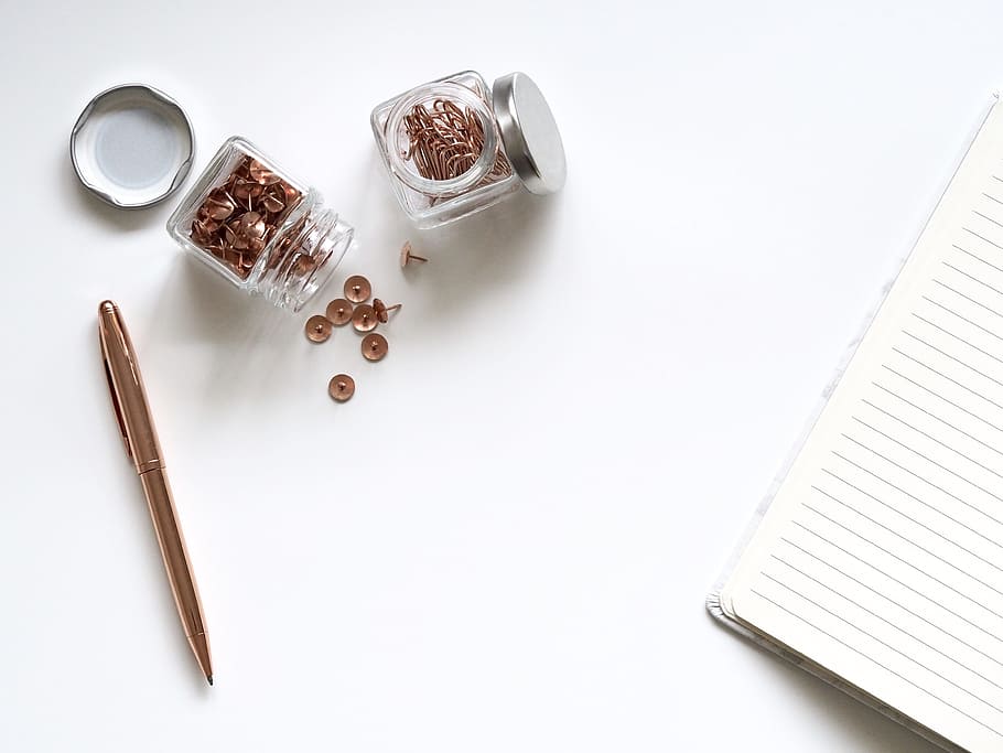 two jars of thumbtacks beside lined notebook and gold retractable pen, HD wallpaper