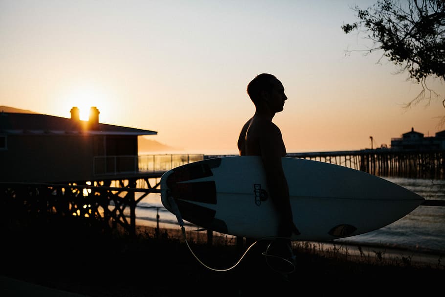 Dawn Patrol, man carrying surfboard, surfer, pier, silhouette HD wallpaper