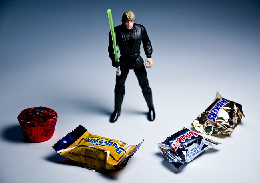 Luke Skywalker action figure behind four assorted-brand chocolate packs, HD wallpaper