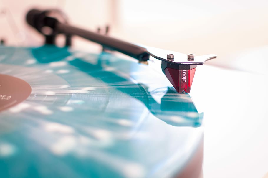 selective focus photo of blue and black turntable, close up photo of red and black frame