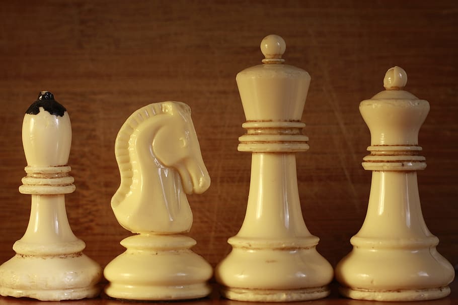 closeup photography of four bishop, horse, king and queen chess pieces