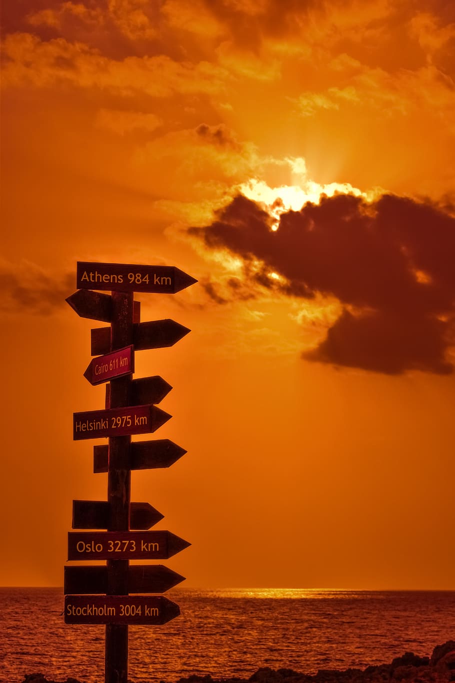 signposts, signs, distance from, sunset, orange, sea, sky, clouds HD wallpaper