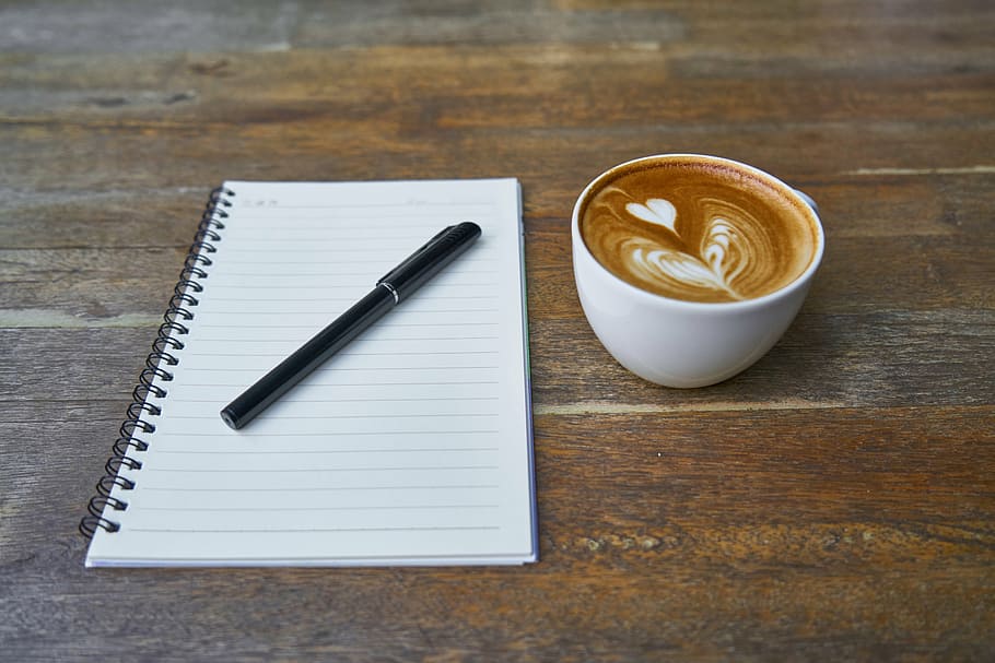 black pen on spiral notebook beside cappuccino art, coffee, caffeine, HD wallpaper
