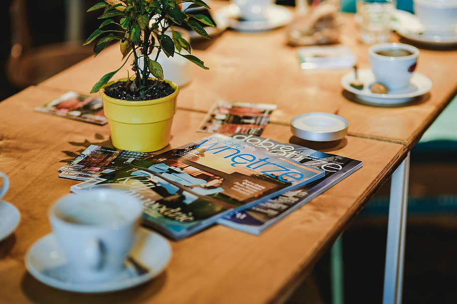 Laptop, a smartphone, magazines and cups of coffee on a table HD wallpaper