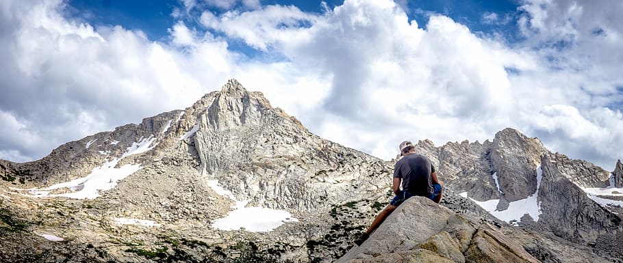 Summiting the Sierra - Yosemite, Cali, USA, man sitting on rock formation looking at mountain during daytime HD wallpaper