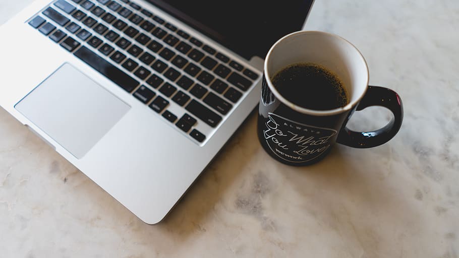 coffee in mug beside MacBook Pro, MacBook Pro and black ceramic mug HD wallpaper