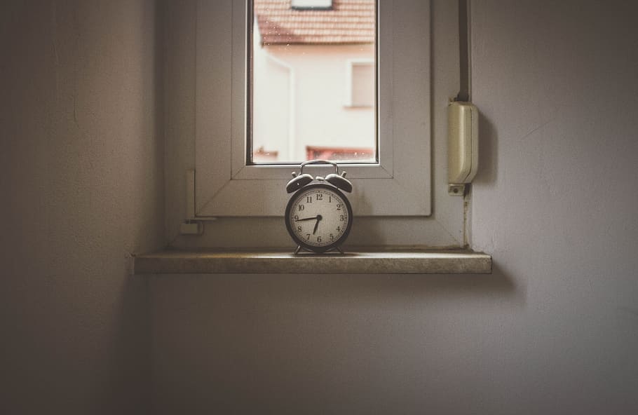 white alarm clock on window still, white bell alarm clock near cabinet