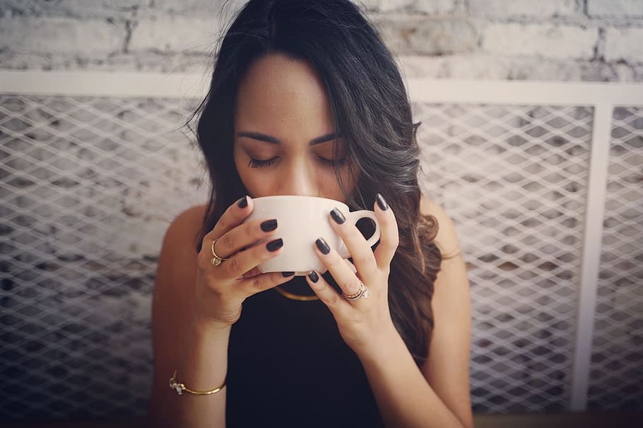 woman wearing black sleeveless top holding white ceramic teacup HD wallpaper