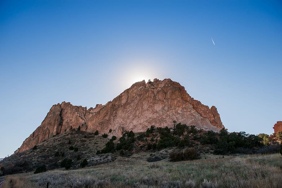 brown mountain near trees low angle photograph, brown mountain surrounded by trees during daytime HD wallpaper