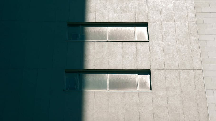 Concrete building with horizontal windows half in shadow, gray case HD wallpaper