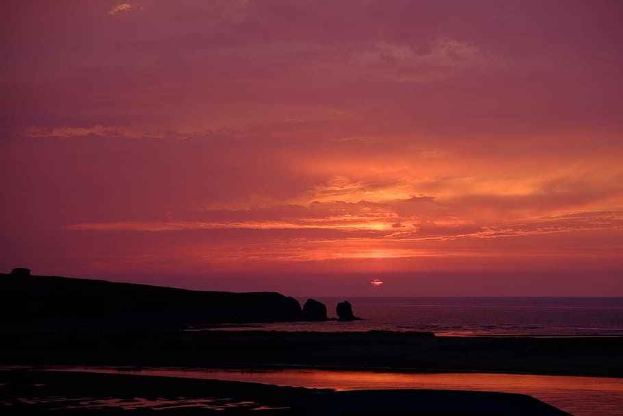 silhouette of island under cloudy sky photo taken during sunset HD wallpaper