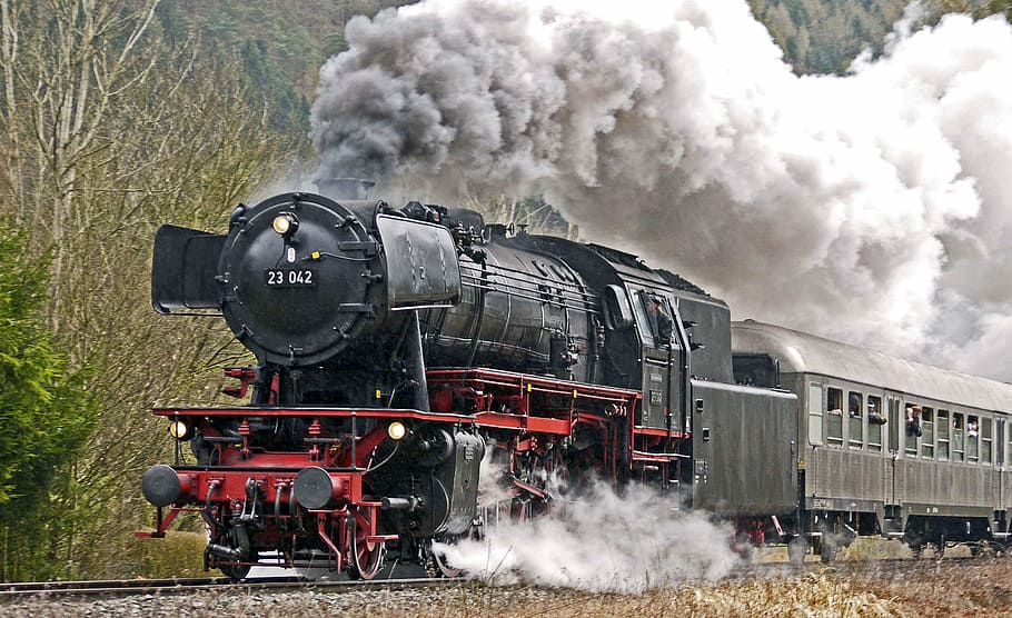 moving black locomotive train covered with thick smoke, full steam