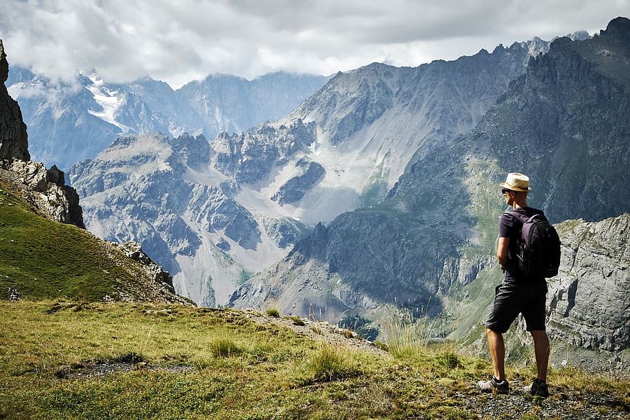 photo of man standing near mountains, man standing near mountain at daytime HD wallpaper
