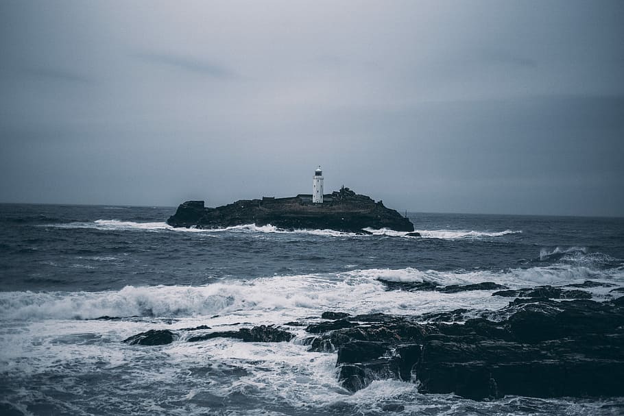 white lighthouse on rock formation surrounded by ocean, white light tower on island in ocean HD wallpaper