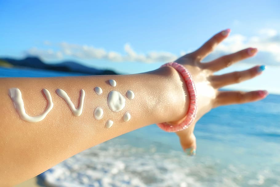 person in pink beaded bracelet and white cream on hand, beach HD wallpaper