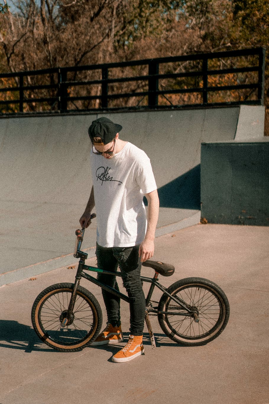 man about to ride on a black BMX bike, man wearing white shirt holding BMX bike, HD wallpaper