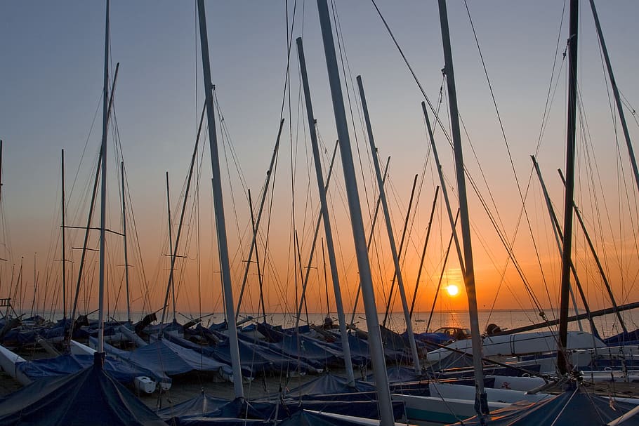 Wide-angle shot of boat masts at sunset on the coast of Whitstable in Kent, England HD wallpaper