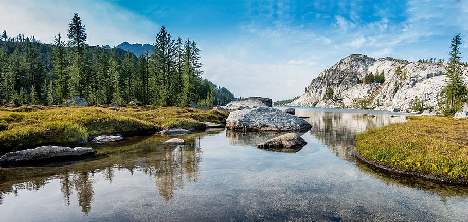 grey and white hills near river, photo of calm body of water across mountain HD wallpaper