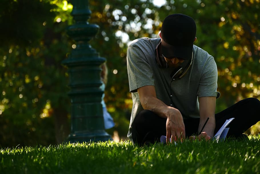 selective focus photography of man sitting on grass and writing on notebook during daytime, selective focus photography of woman writing on grass field, HD wallpaper