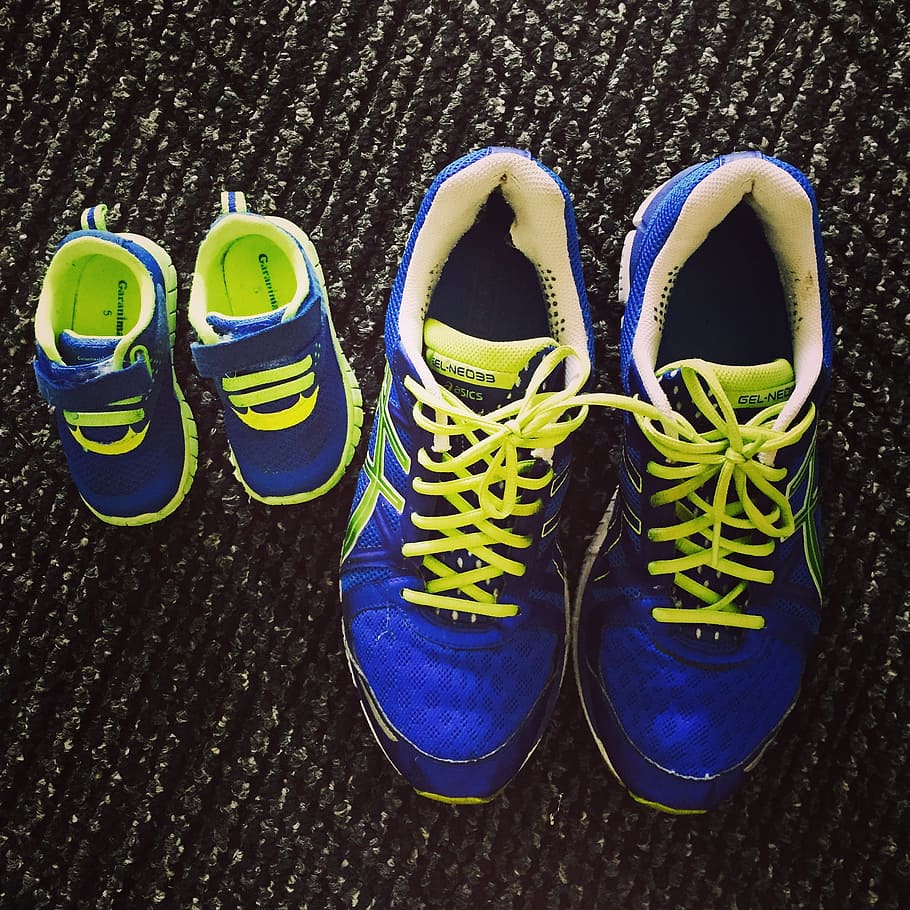 two pairs of toddler's and men's blue-and-white lace-up sneakers on rug