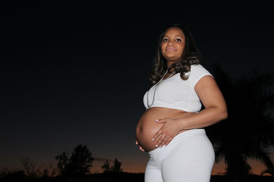 pregnant woman holding her tummy outdoors, family, pregnancy