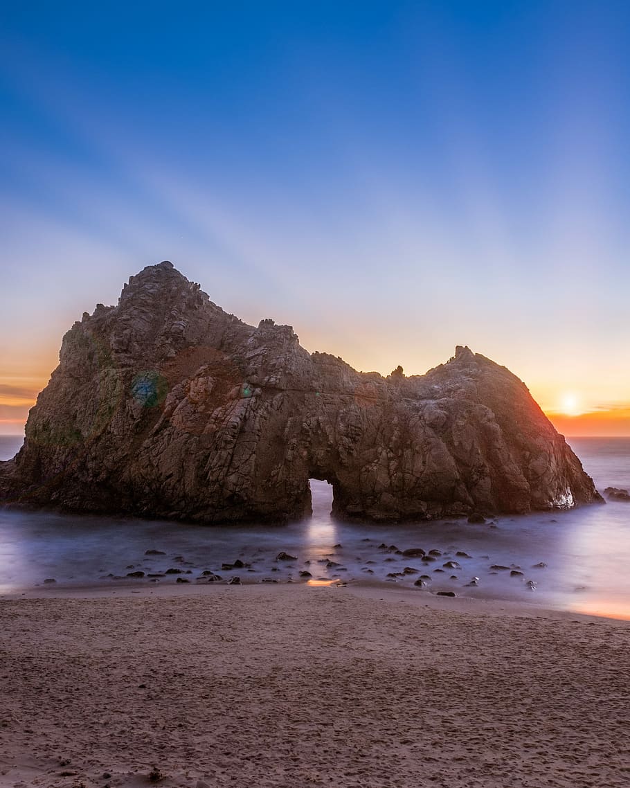 photography of rock formation on body of water, brown rock formation on sea during sunrise HD wallpaper